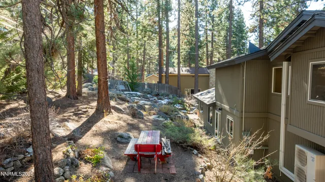 a view of a chairs and table in the back yard of the house