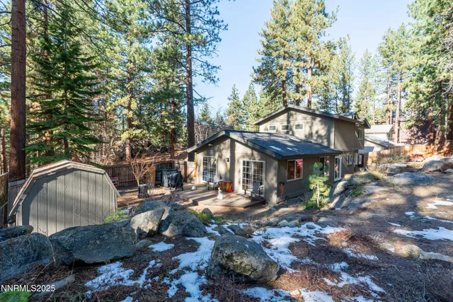 a view of a chairs and fire pit in a backyard