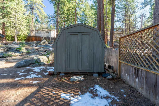 a view of barn with wooden fence next to a road