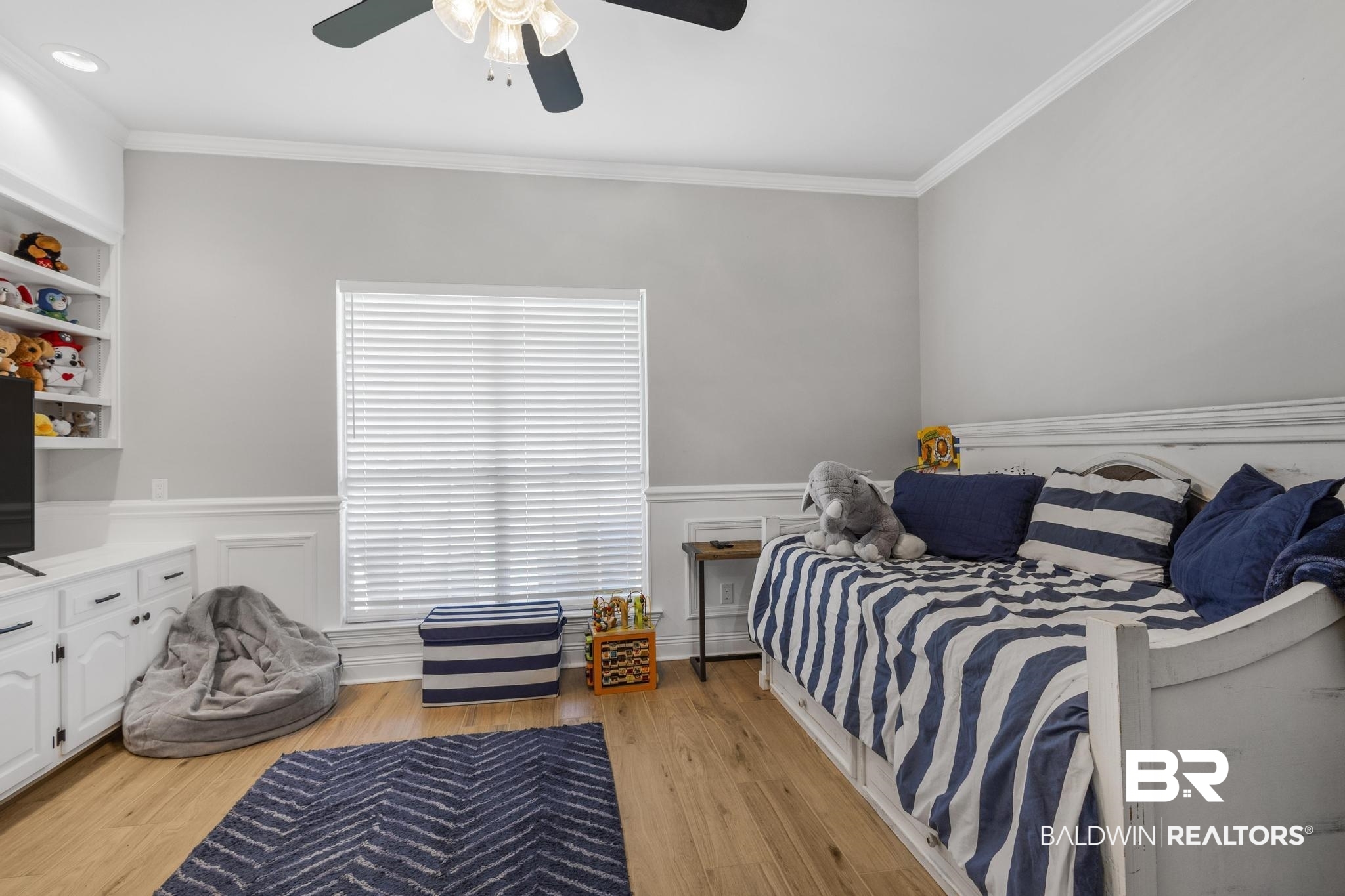 83 Caisson Trace Daphne, AL 36527 - Photo 51 of 63 Spacious room featuring wood-finish flooring, a ceiling fan, crown molding, built-in shelving, and wainscoting
