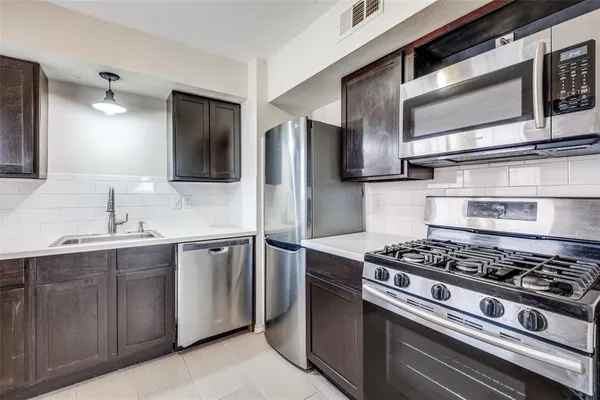a kitchen with stainless steel appliances granite countertop a sink and a stove
