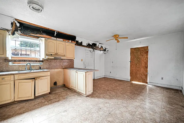 a kitchen with stainless steel appliances granite countertop a refrigerator a sink dishwasher a stove and white cabinets with wooden floor