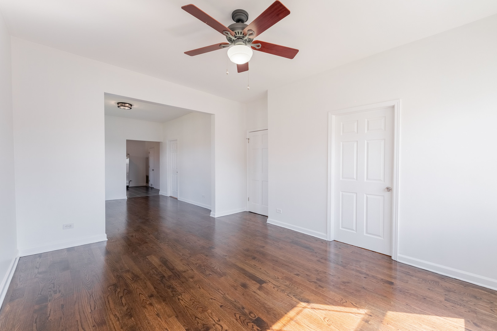 4140 West Maypole Avenue, Unit 2 Chicago, IL 60624 - Photo 3 of 24 an empty room with wooden floor and a ceiling fan