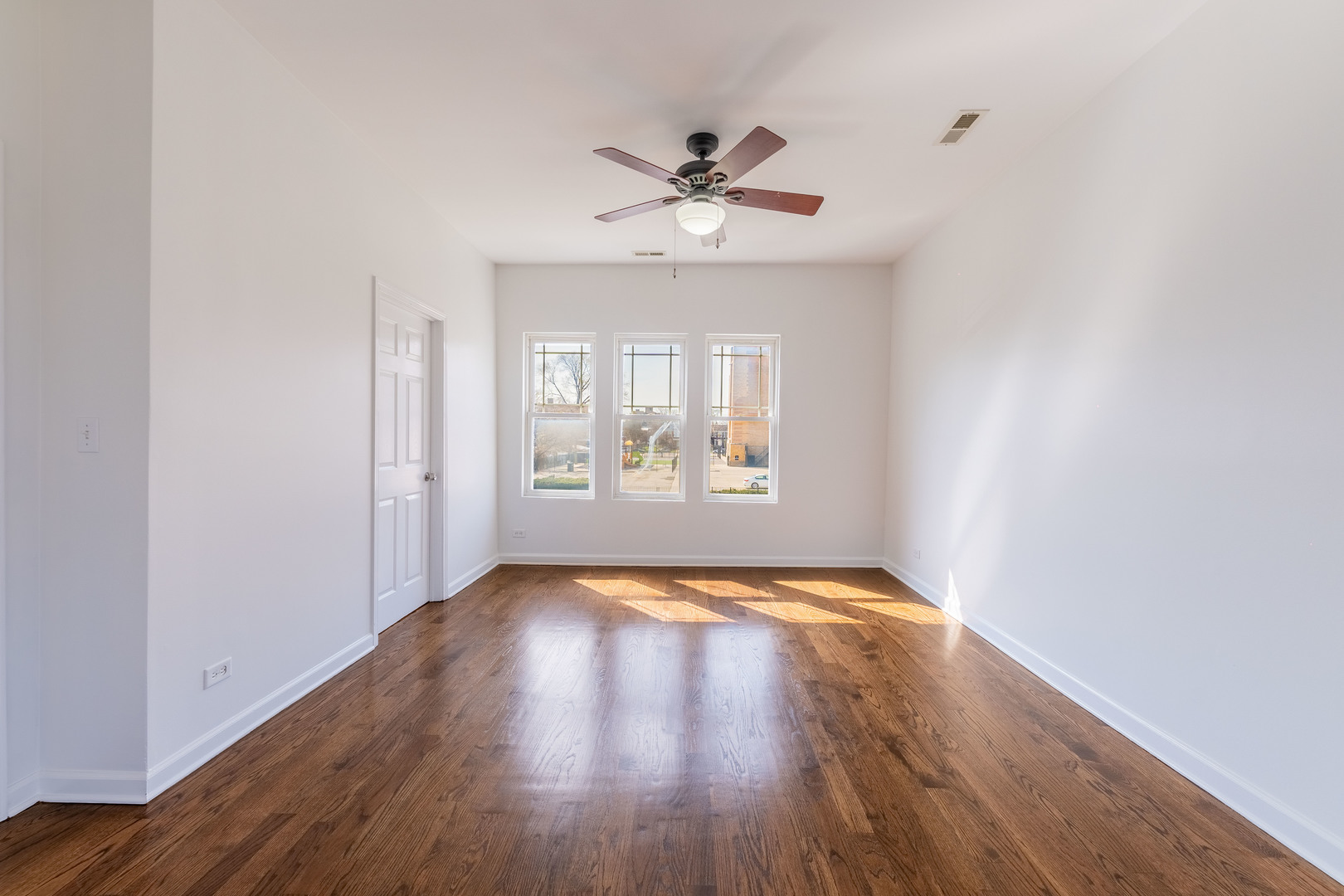 4140 West Maypole Avenue, Unit 2 Chicago, IL 60624 - Photo 5 of 24 a view of an empty room with window and wooden floor