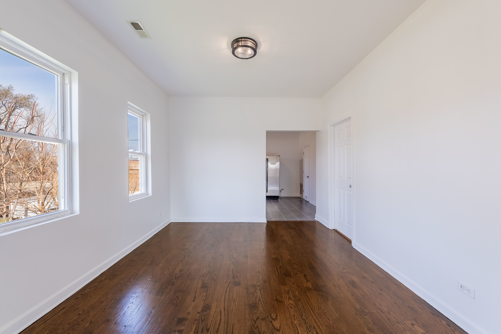 4140 West Maypole Avenue, Unit 2 Chicago, IL 60624 - Photo 6 of 24 a view of an empty room with wooden floor and a window