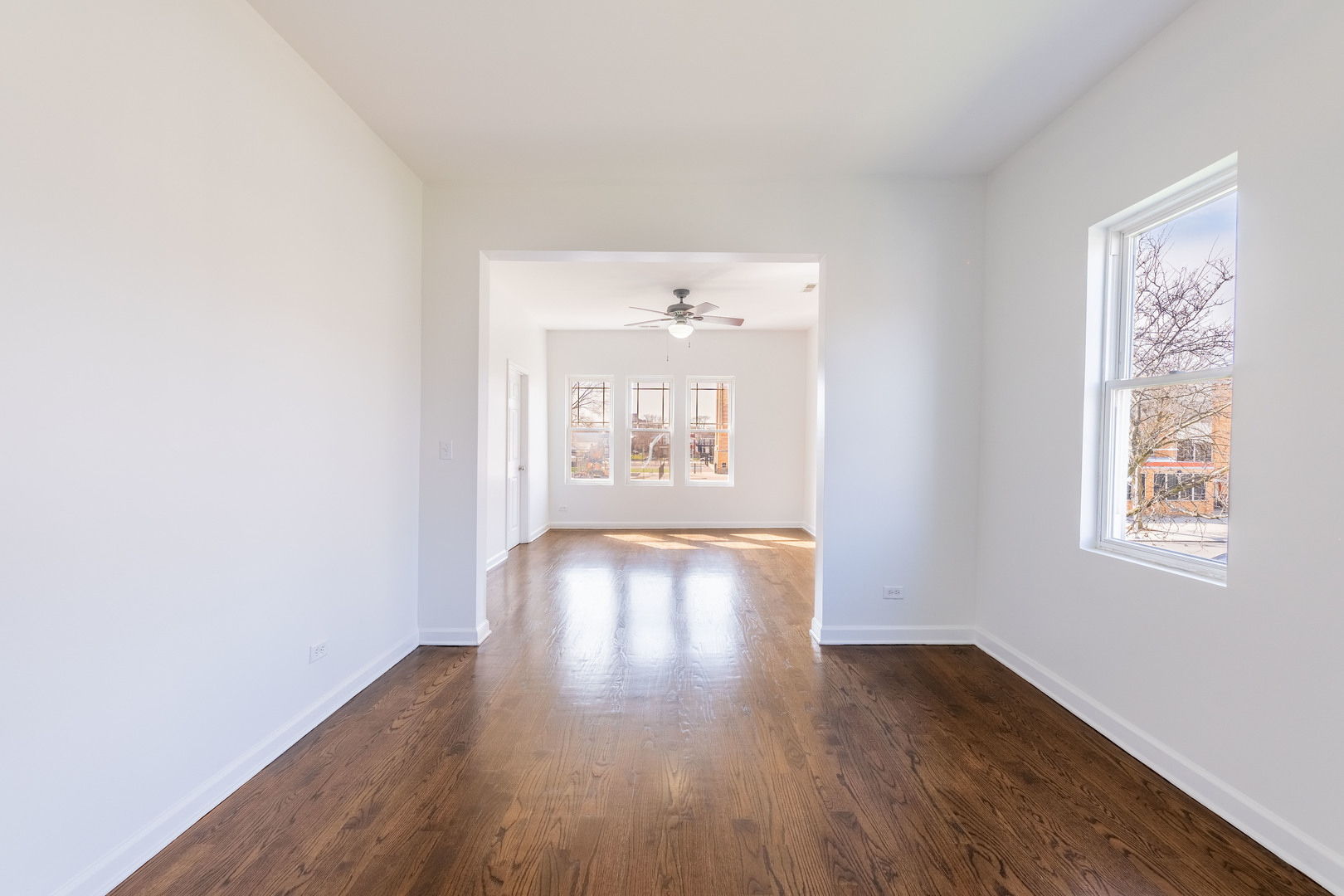 4140 West Maypole Avenue, Unit 2 Chicago, IL 60624 - Photo 7 of 24 an empty room with wooden floor and windows