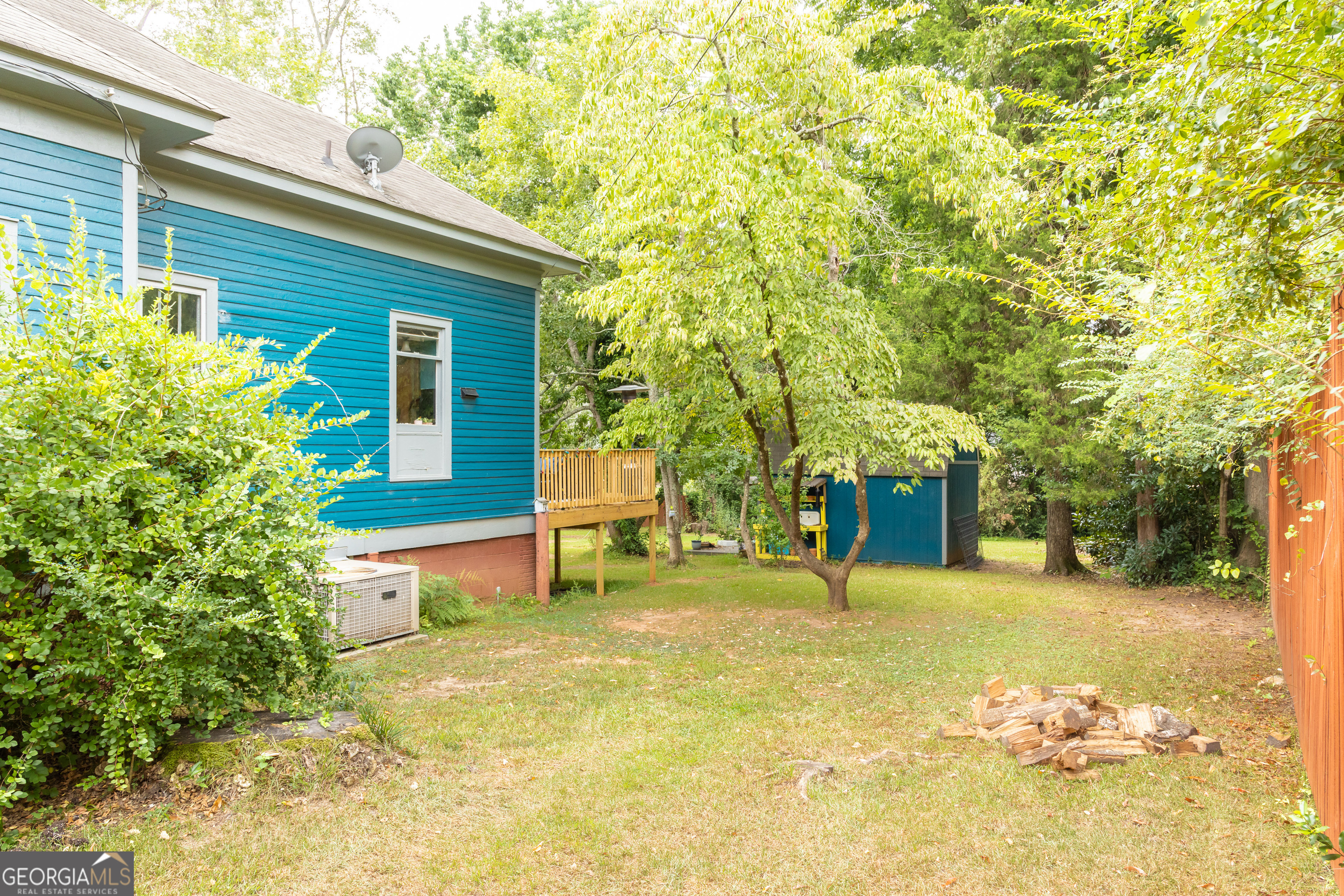 308 Howell Street Thomaston, GA 30286 - Photo 30 of 46 a backyard of a house with large trees and wooden fence