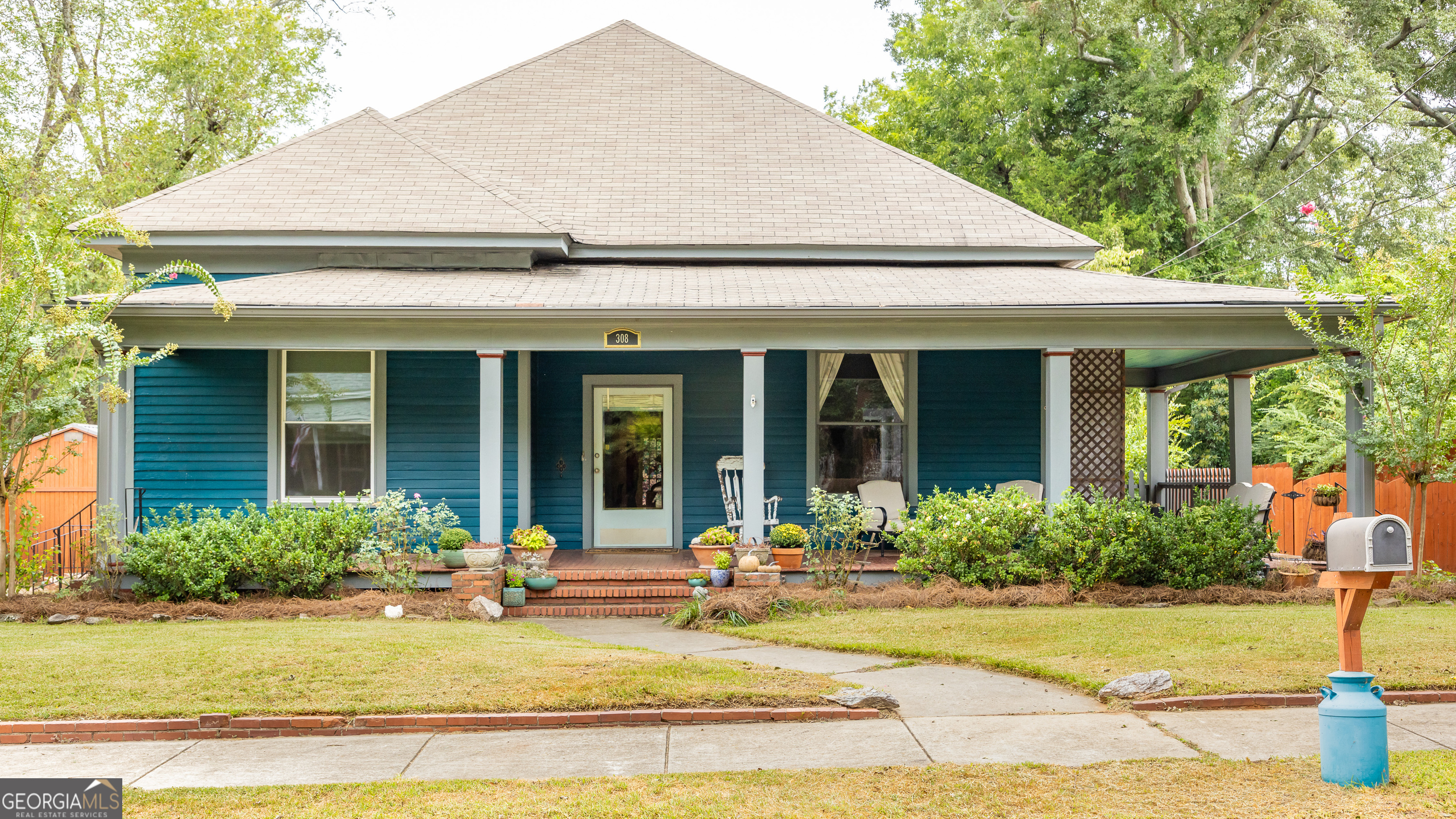 308 Howell Street Thomaston, GA 30286 - Photo 46 of 46 a view of a white house with a small yard plants and large tree
