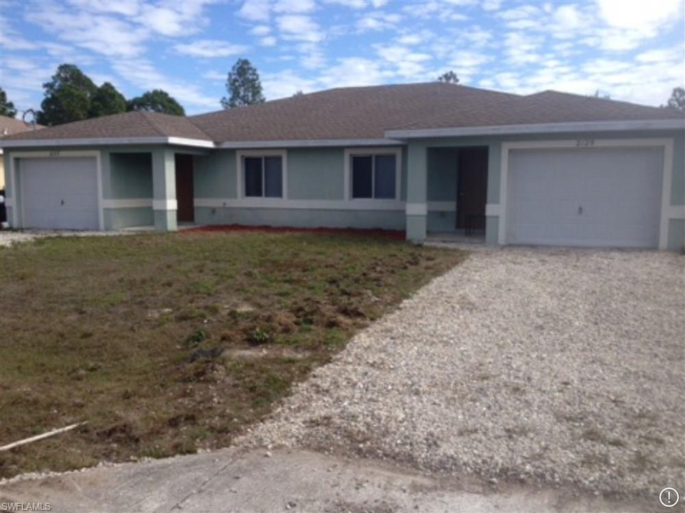 2127-2129 Wilson Road Lehigh Acres, FL 33973 - Photo 1 of 1 a front view of a house with garage