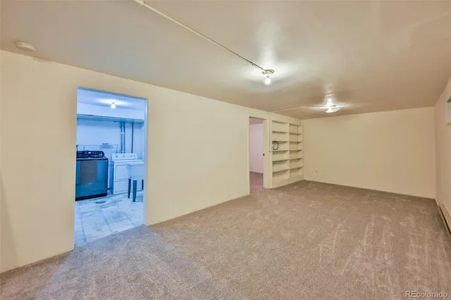 a view of an empty room with a kitchen