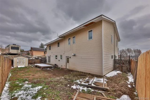 a backyard of a house with barbeque oven table and chairs