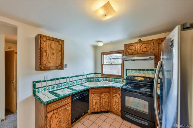 a kitchen with granite countertop a stove and a refrigerator