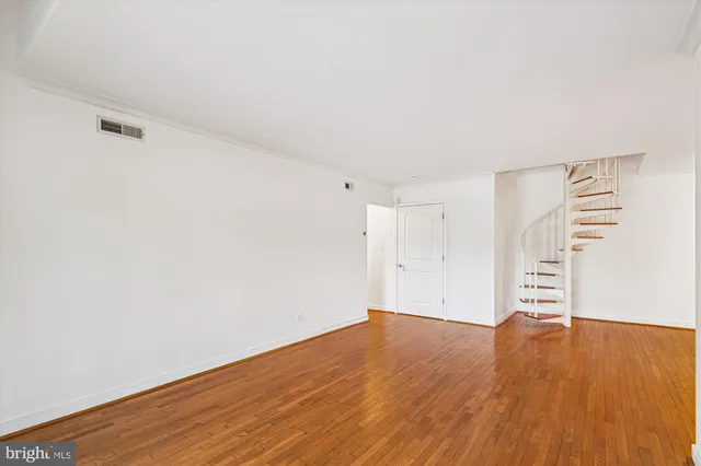a view of empty room with wooden floor
