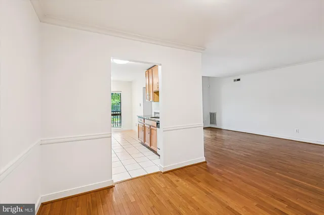 a view of empty room with wooden floor