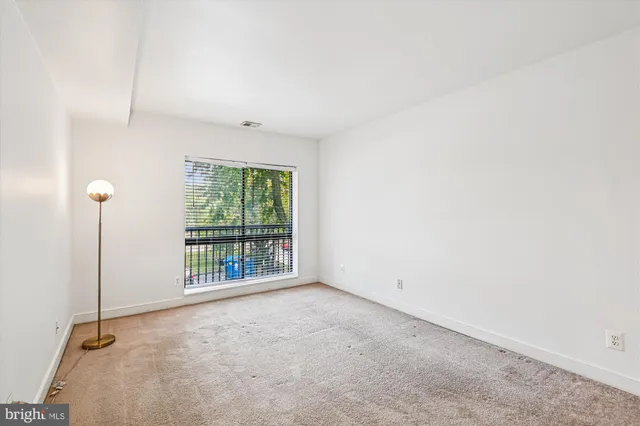 a view of an empty room with a window and front door