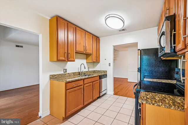 a kitchen with stainless steel appliances granite countertop a sink stove and cabinets