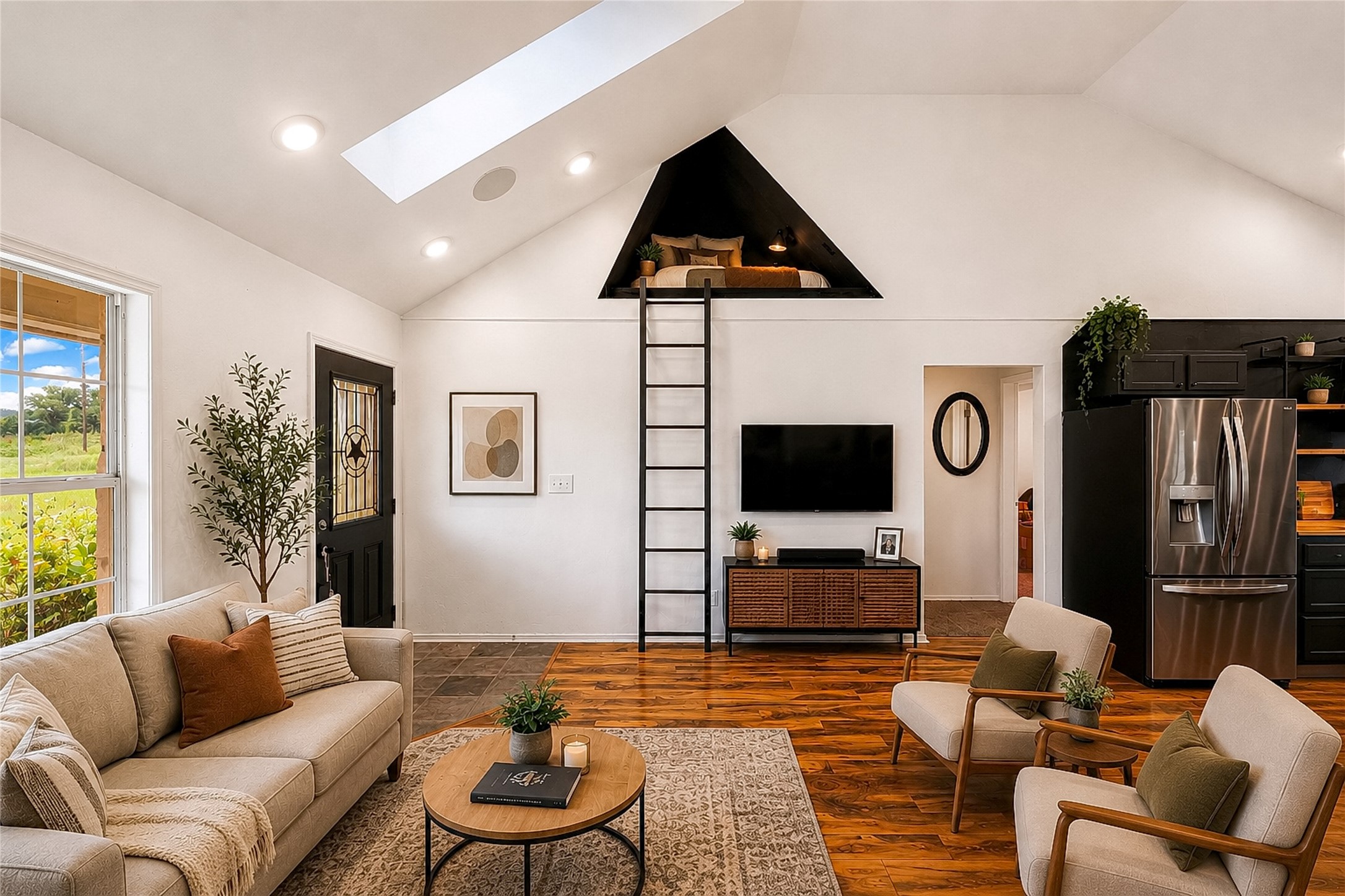 358 Easley Road Smithville, TX 78957 - Photo 7 of 36 Virtually staged - Natural light floods this living area, showcasing the vaulted ceiling with a clever lofted sleeping nook accessible by a sturdy ladder.