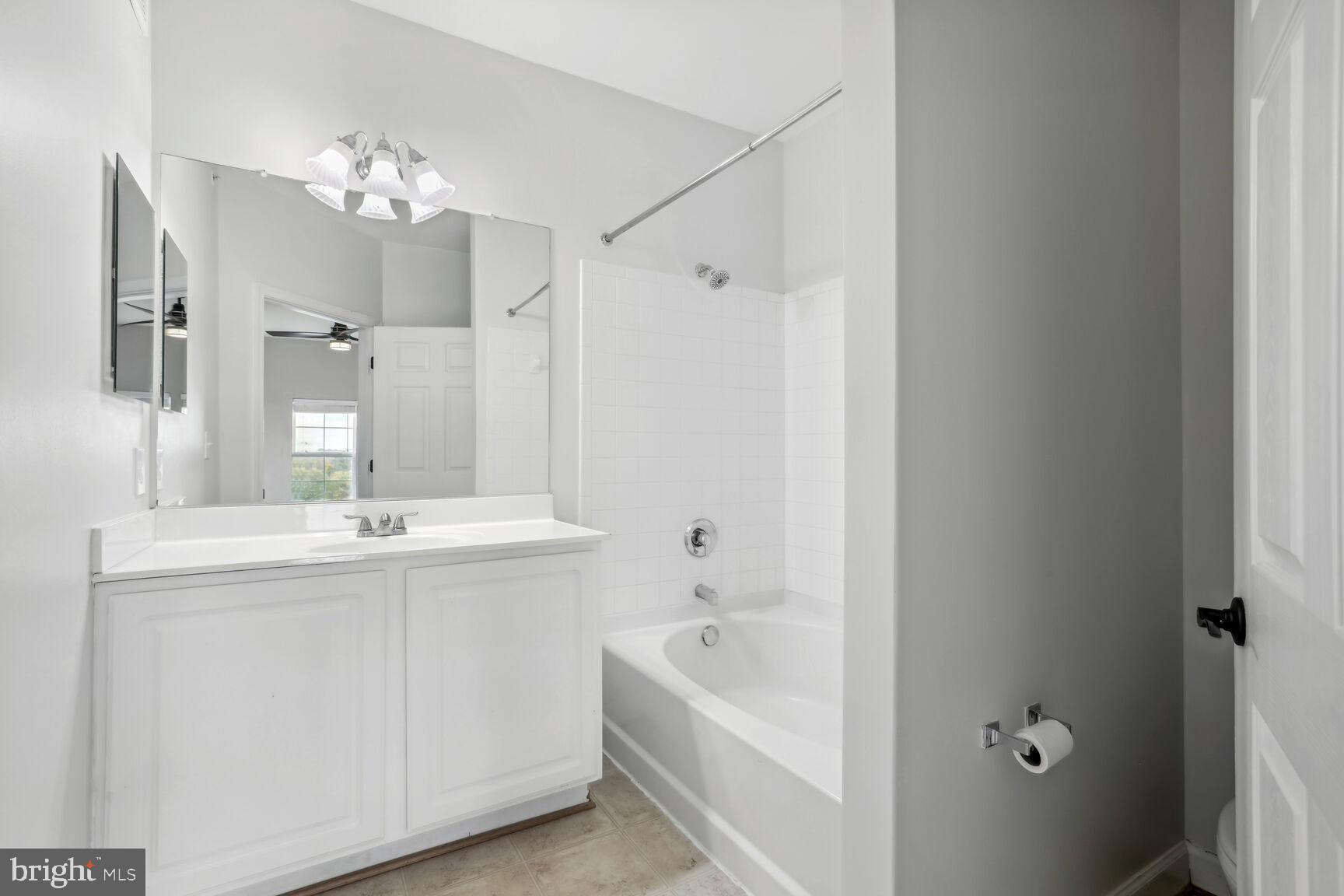 42379 Goldenseal Square Brambleton, VA 20148 - Photo 18 of 20 a bathroom with a bathtub a sink and a mirror