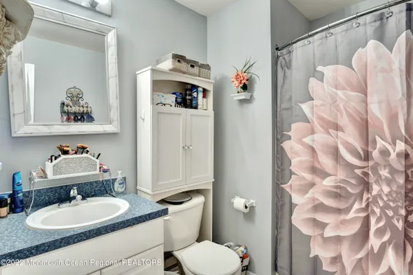 a bathroom with a sink vanity mirror and toilet