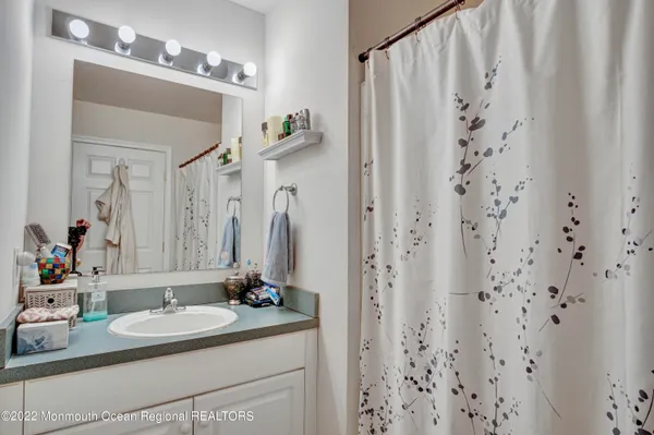 a bathroom with a granite countertop sink a mirror and a shower curtain