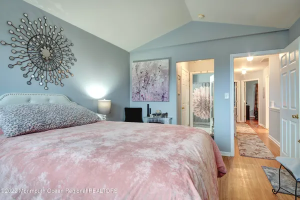 a spacious bedroom with a large bed and a chandelier