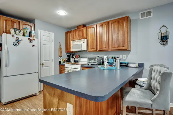 a kitchen with stainless steel appliances granite countertop a refrigerator a sink a stove and white cabinets