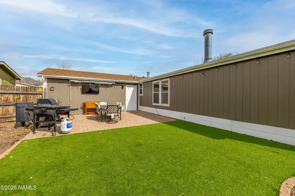 a view of a patio with table and chairs a barbeque with wooden fence