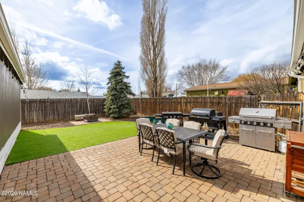 a view of a patio with dining table and chairs with wooden fence
