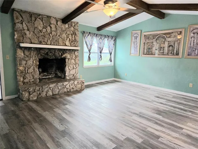 an empty room with windows and fireplace