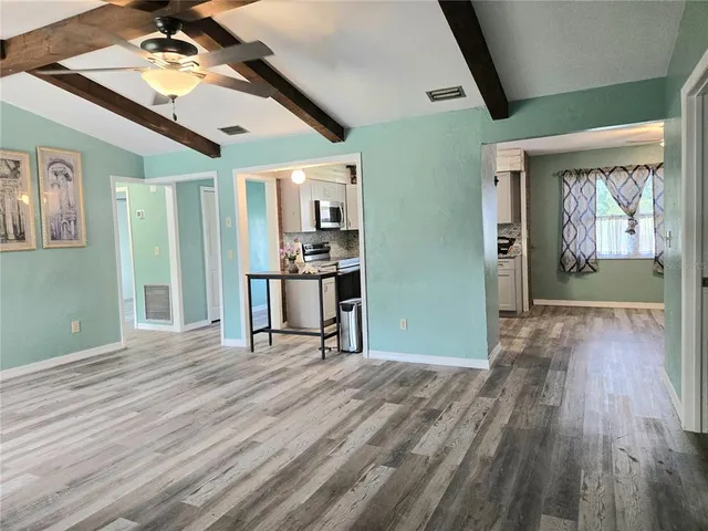 a view of a livingroom with wooden floor and a ceiling fan