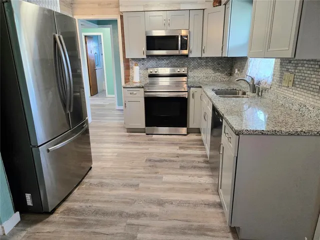 a kitchen with stainless steel appliances granite countertop a refrigerator stove and microwave