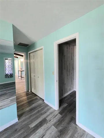 a view of a hallway with wooden floor and windows