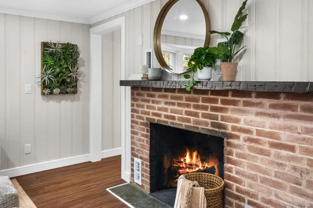 a living room with a fireplace and a potted plant