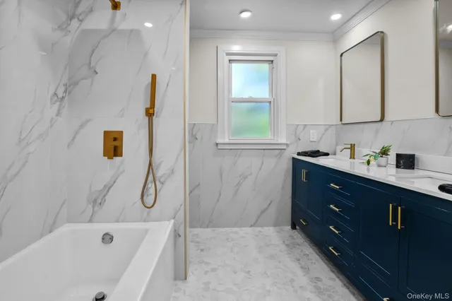 a bathroom with a tub sink and mirror