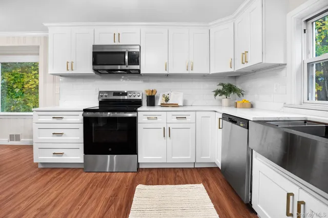 a kitchen with stainless steel appliances a stove a sink and a microwave
