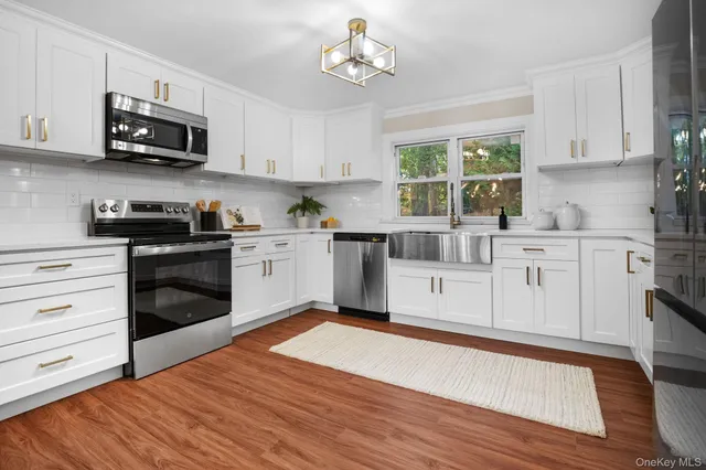 a kitchen with stainless steel appliances granite countertop a stove a sink and a microwave