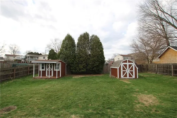 a view of a house with backyard and fence