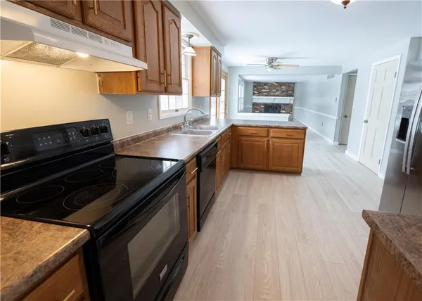 a kitchen with stainless steel appliances granite countertop a stove a sink and a refrigerator