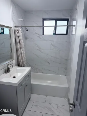 a bathroom with a bathtub a sink a vanity and a shower