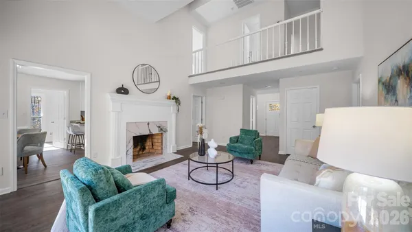 a living room with furniture a fireplace and a chandelier