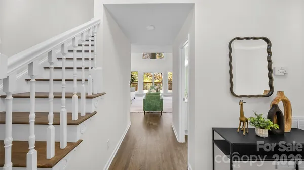 a view of a hallway with wooden floor and entryway