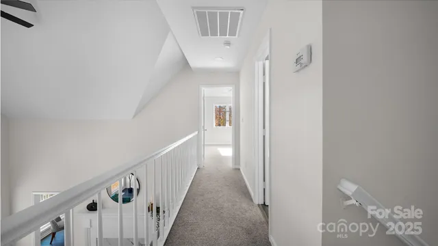a view of a hallway with wooden floor and entryway
