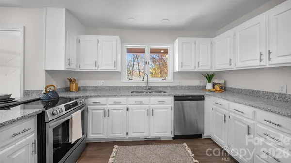 a kitchen with stainless steel appliances granite countertop a sink stove and cabinets