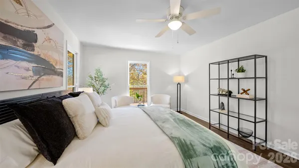 a bedroom with a bed a dresser with wooden floor