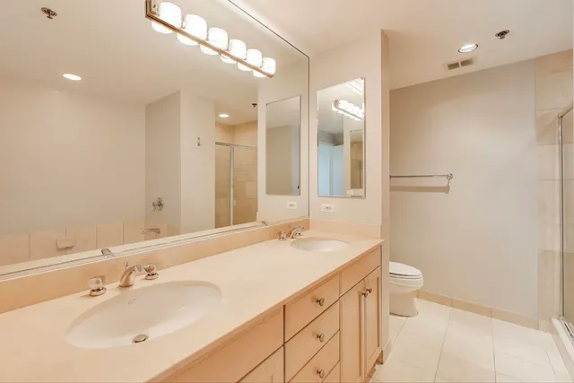 a bathroom with a double vanity sink a toilet and a mirror