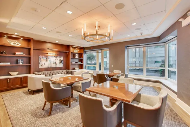 a room with lots of furniture a chandelier and a large window