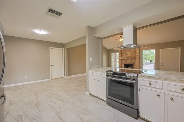 a kitchen with a stove and white cabinets