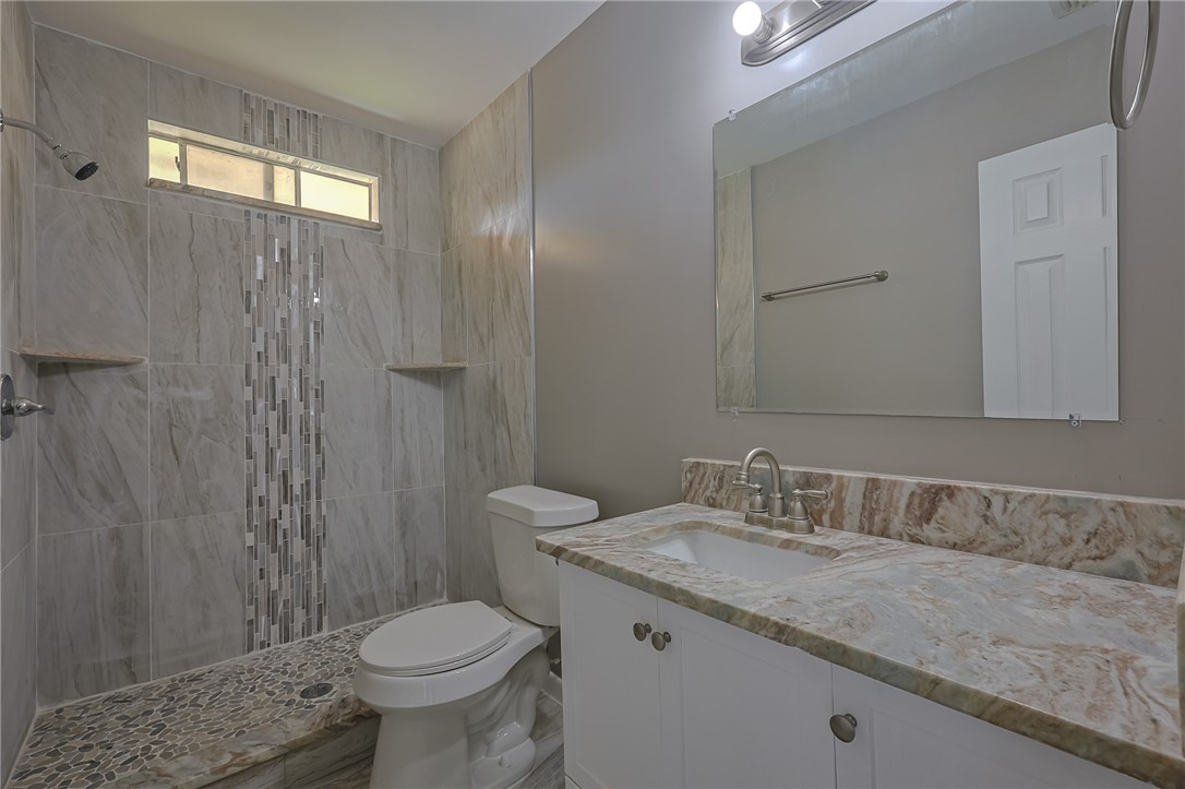 4314 Caplin Drive Corpus Christi, TX 78410 - Photo 17 of 25 a bathroom with a granite countertop toilet sink and mirror