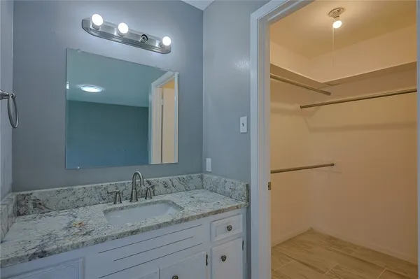a bathroom with a granite countertop sink and a mirror