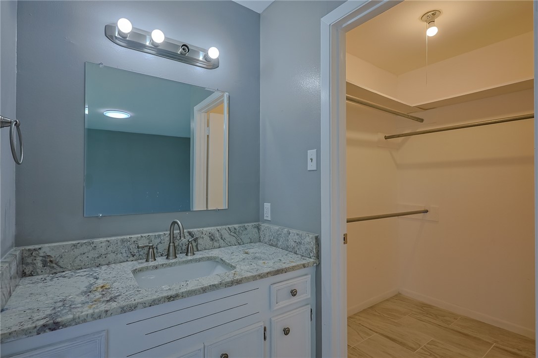 4314 Caplin Drive Corpus Christi, TX 78410 - Photo 20 of 25 a bathroom with a granite countertop sink and a mirror